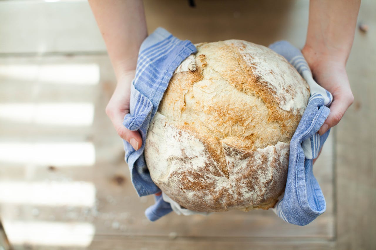 Hands holding a loaf of bread.
